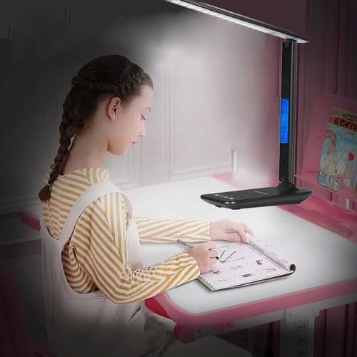 Person at desk using Lamp Plus 3 in 1 lamp with phone charger, clock and thermostat