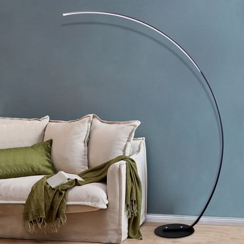 RGBW Modern Curve Floor Lamp with arched design above cream sofa with green accents