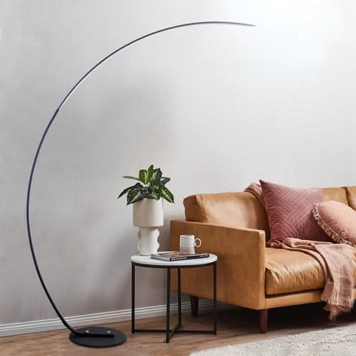 RGBW Modern Curve Floor Lamp with arched black frame next to brown leather chair and side table