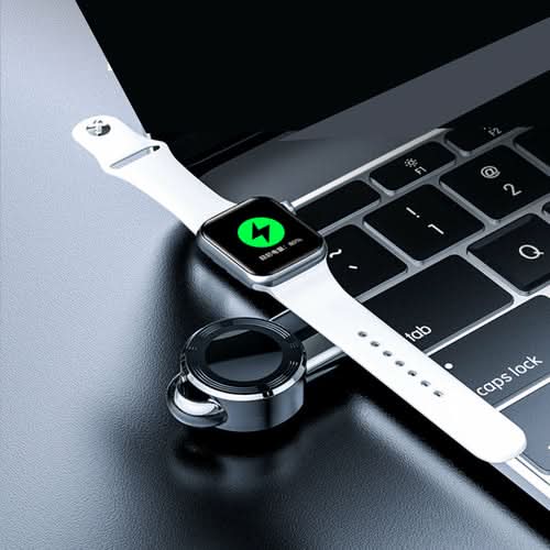 Apple iWatch USB Charger positioned next to laptop keyboard with smartwatch displaying green icon