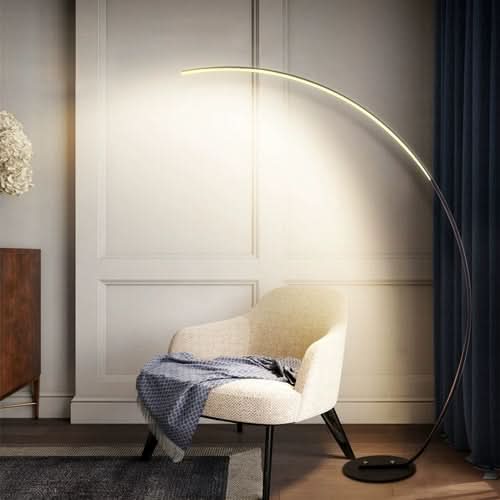 RGBW Modern Curve Floor Lamp arching over a cream accent chair in a contemporary living room