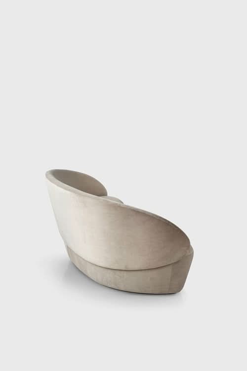 Naïve Sofa, cream upholstered curved armchair shown from the side