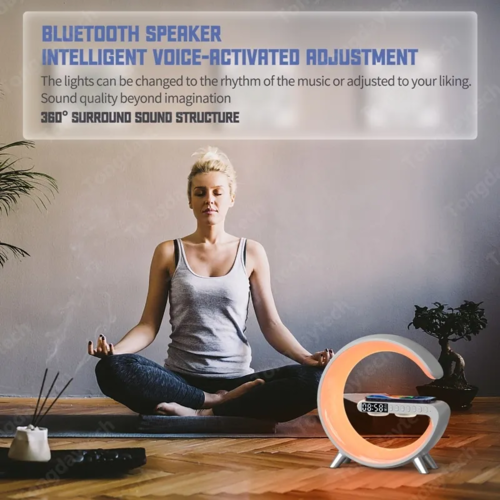 Multifunctional wireless charger alarm clock speaker in orange and white on wooden floor near woman meditating