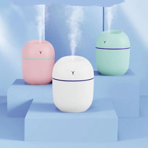 Three portable humidifiers in pink, white, and mint with LED lights and USB aroma diffuser function